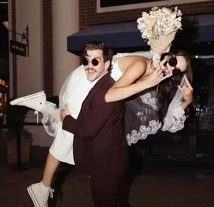 Novio llevando a novia al hombro